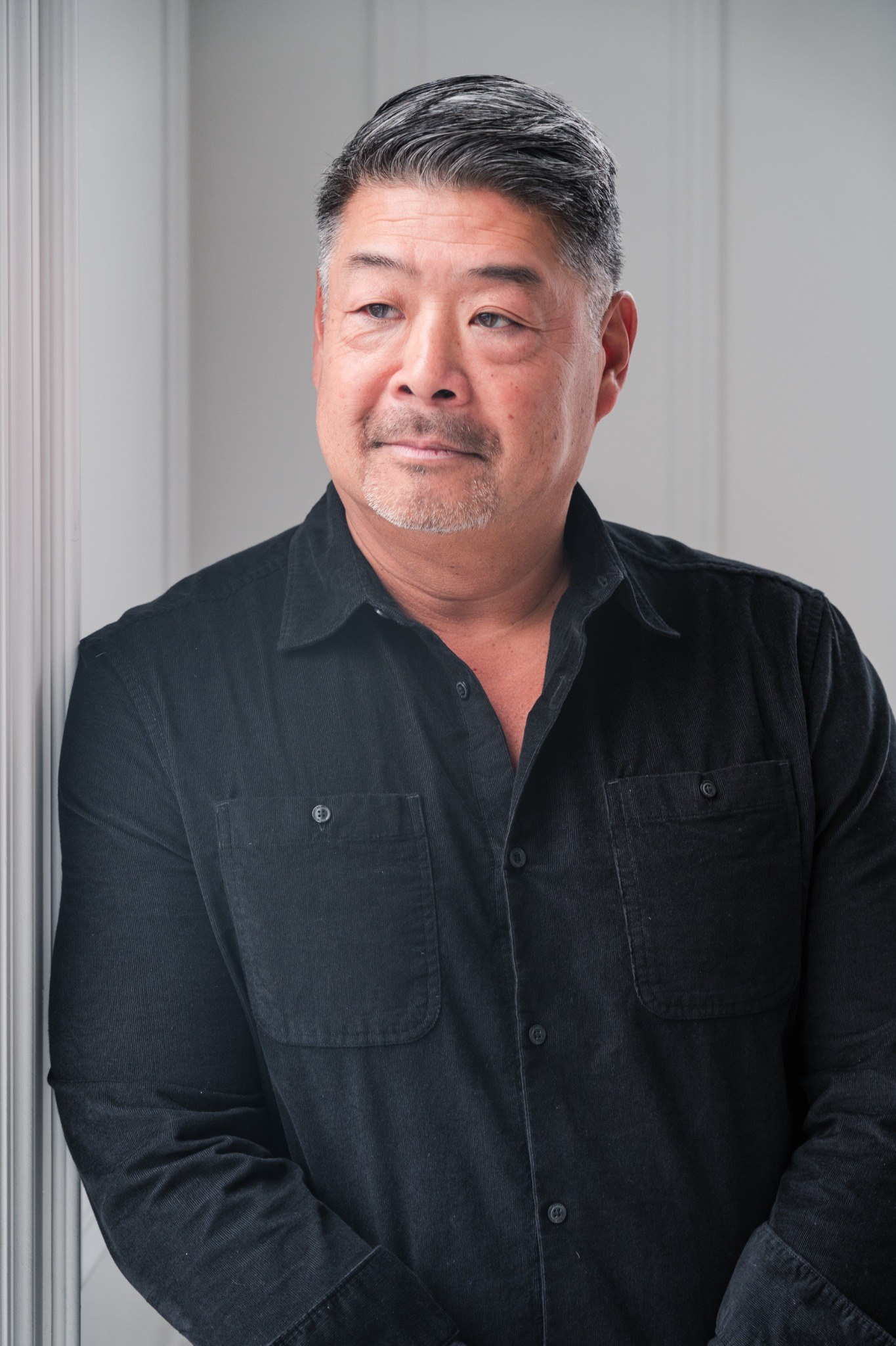 Atsushi Yasuda standing beside a window